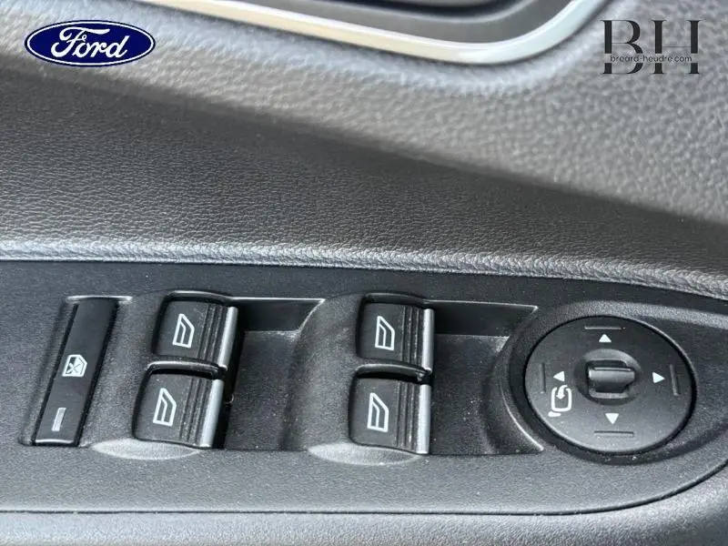 Gros plan sur les commandes des vitres électriques et réglage des rétroviseurs côté conducteur d'une Ford B-MAX blanc glacier.