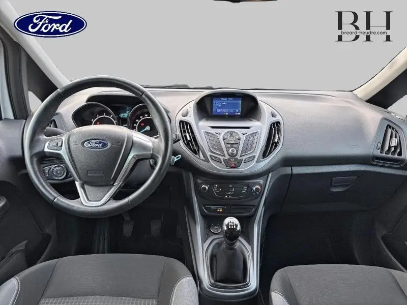 Intérieur avant de la Ford B-MAX blanc Glacier 2017 avec volant cuir, écran tactile et boîte manuelle visible au centre.