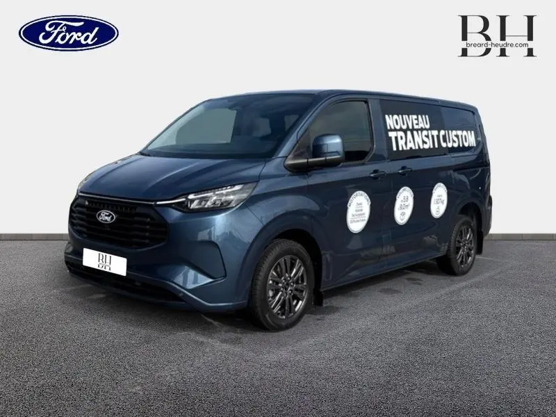 Ford Transit Custom bleu azur métallisé vu de 3/4 avant droit avec marquage publicitaire blanc sur la porte latérale