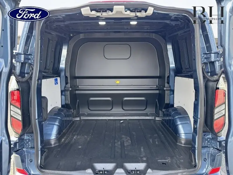 Vue arrière intérieure du Ford Transit Custom bleu azur métallisé montrant l'espace de chargement vide et la cloison pleine.