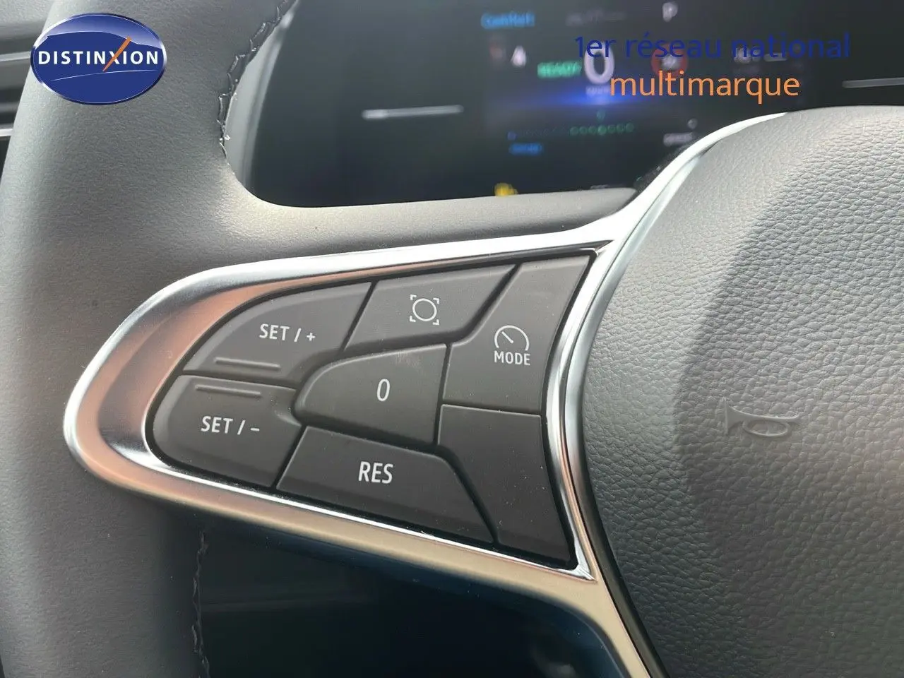 Gros plan sur les commandes de régulateur de vitesse au volant d'un Renault Captur gris Cassiopée métal toit noir.