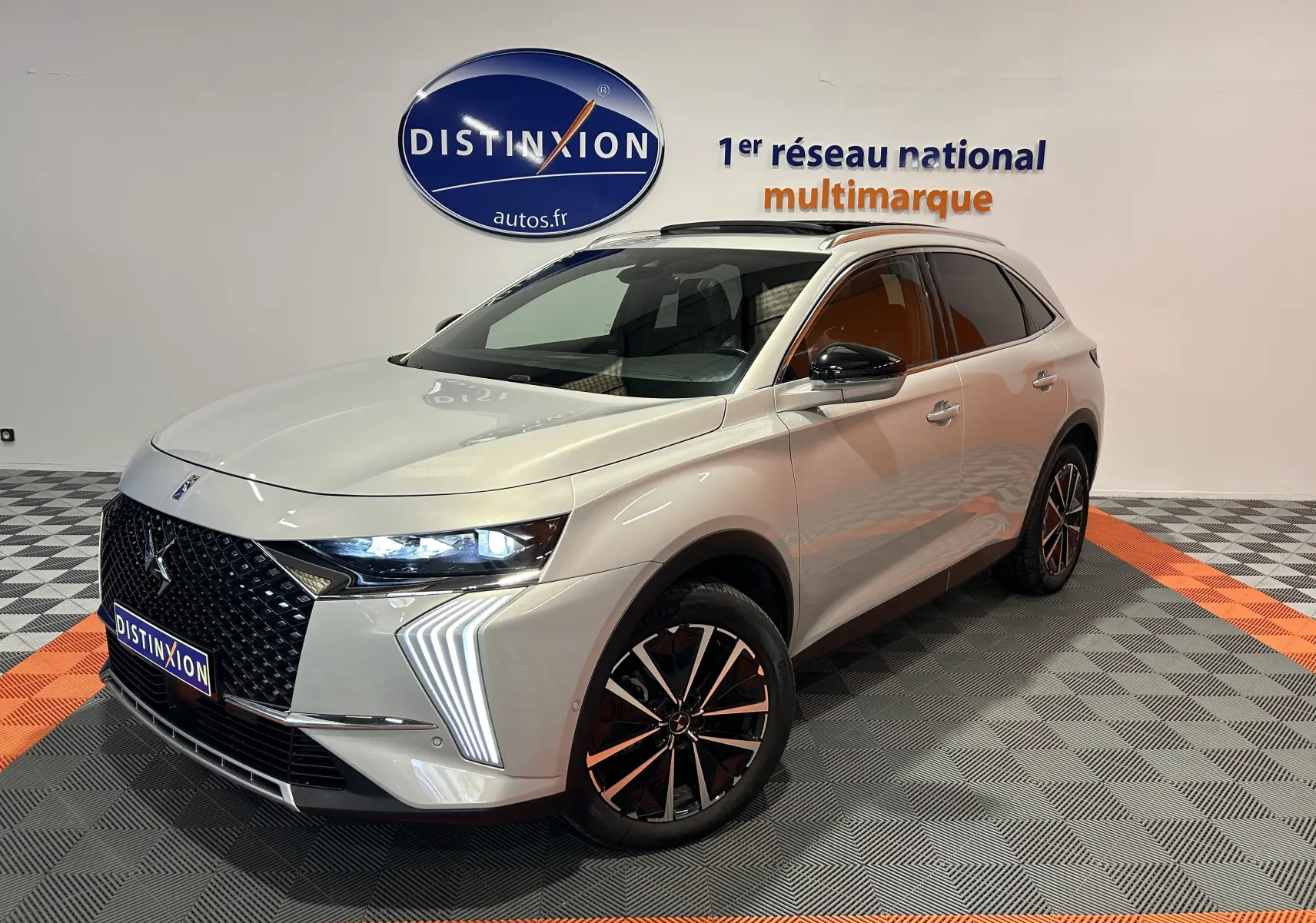 DS7 BlueHDI 130 2024 en Chrystal pearl, vue 3/4 avant droit avec feux LED et jantes noires distinctives.