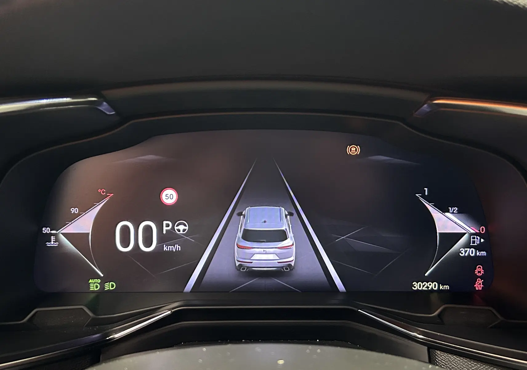 Tableau de bord numérique du DS7 BlueHDI 130, affichant la voiture vue de dessus et les indicateurs de vitesse et carburant.
