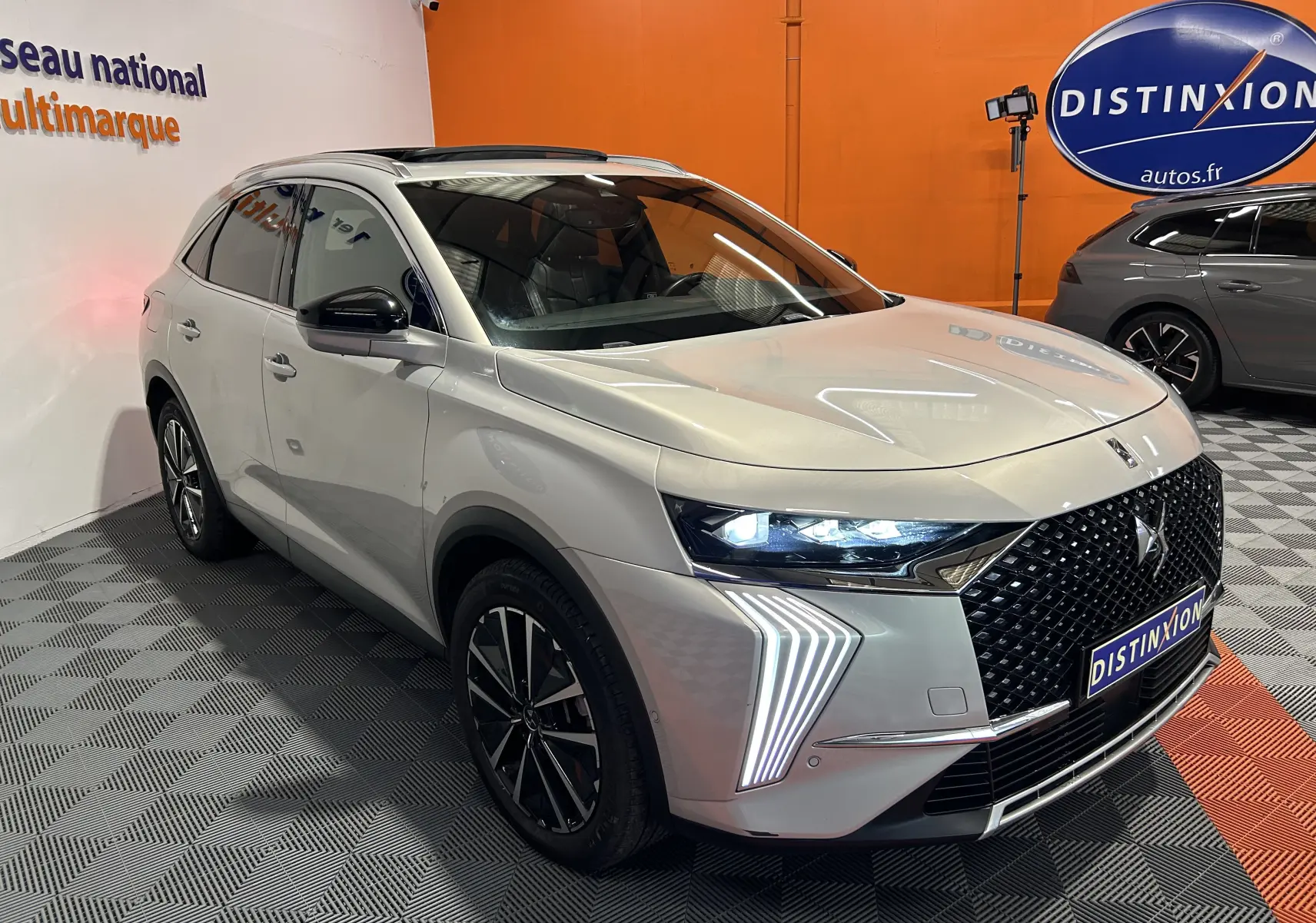 DS7 BlueHDI 130 2024 en Chrystal pearl, vue 3/4 avant avec feux LED et calandre noire distinctive.