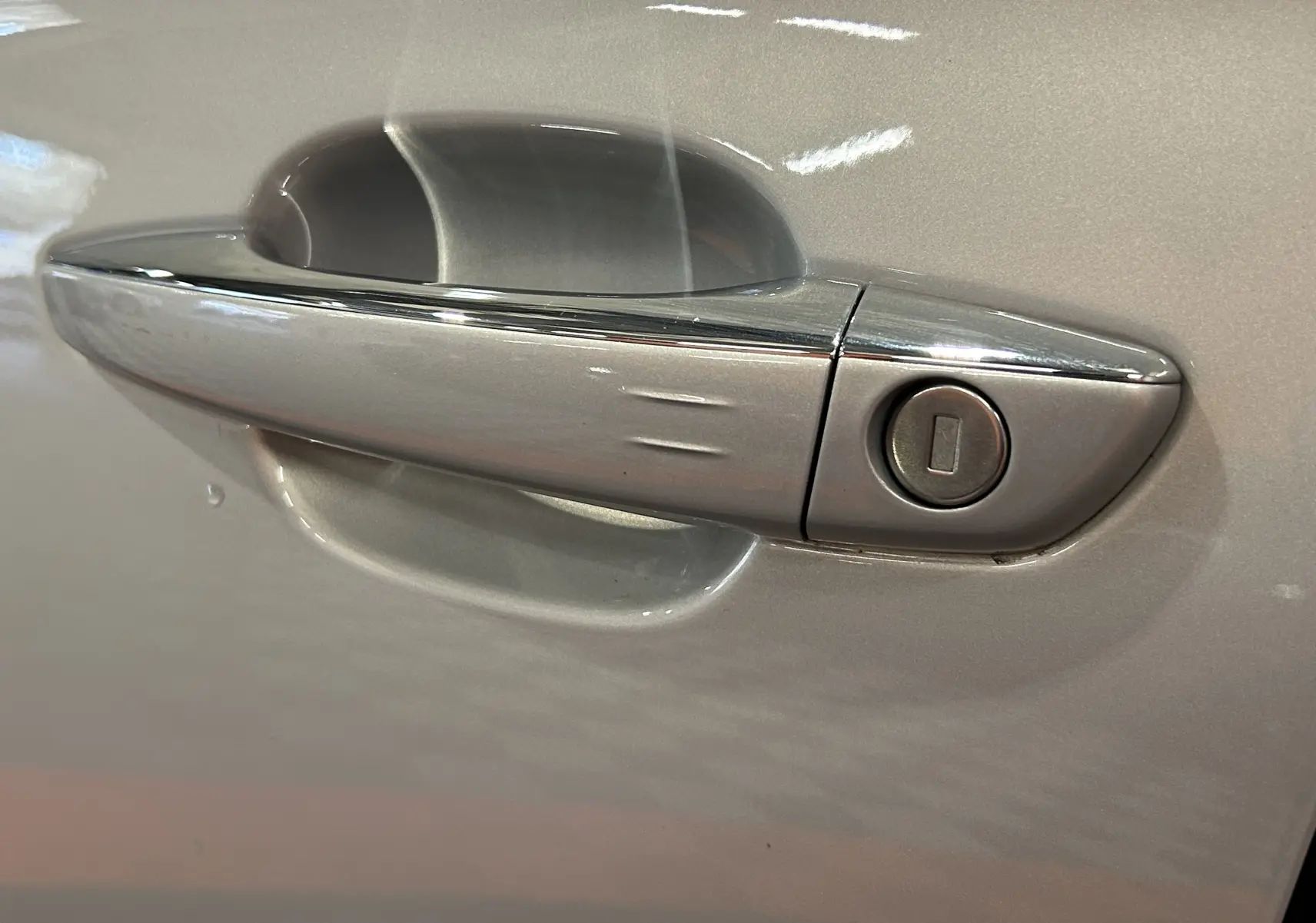 Poignée de porte chromée sur la portière côté gauche d'un DS7 2024 couleur Chrystal pearl.