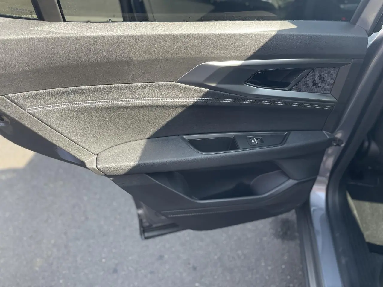 Vue rapprochée de la porte arrière droite gris foncé du Renault Rafale 2025 avec surpiqûres argentées et commande de vitre.