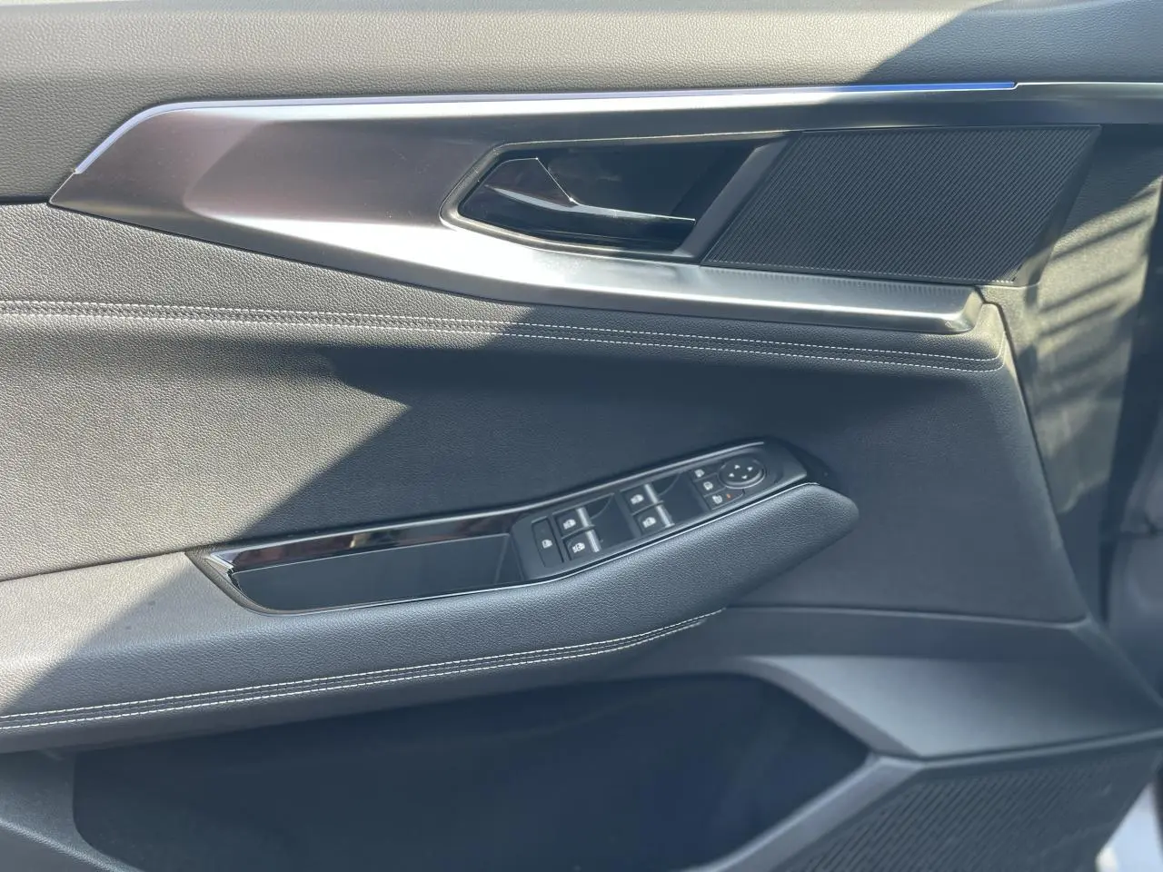 Gros plan sur la porte côté gauche de la Renault Rafale 2025, avec garniture noire et commandes de vitres intégrées.