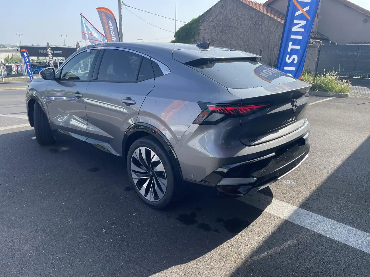 Vue 3/4 arrière droite du Renault Rafale 2025 gris avec toit noir, feux arrière LED et jantes alliage diamantées noires.