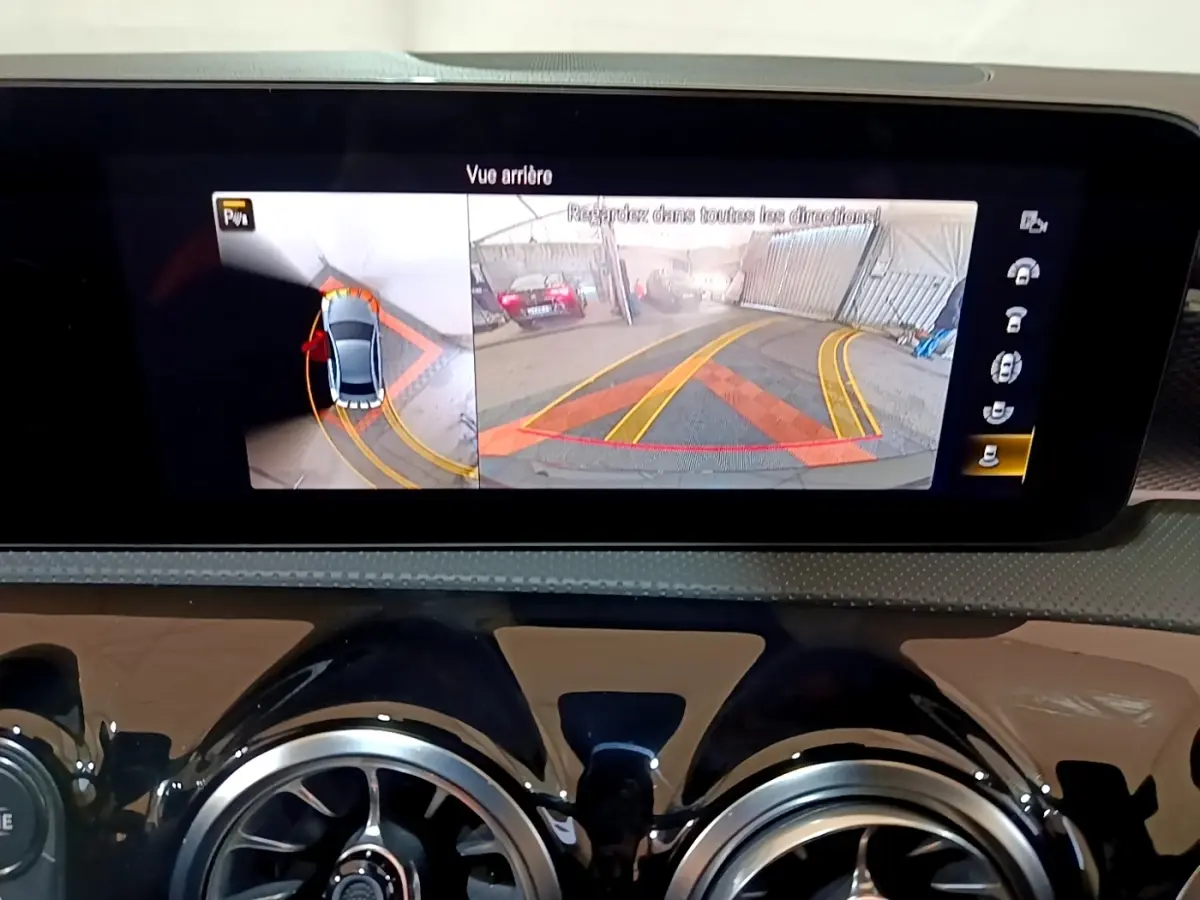 Écran central affichant la caméra de recul et vue 360° dans une Mercedes Classe A noire, tableau de bord moderne.