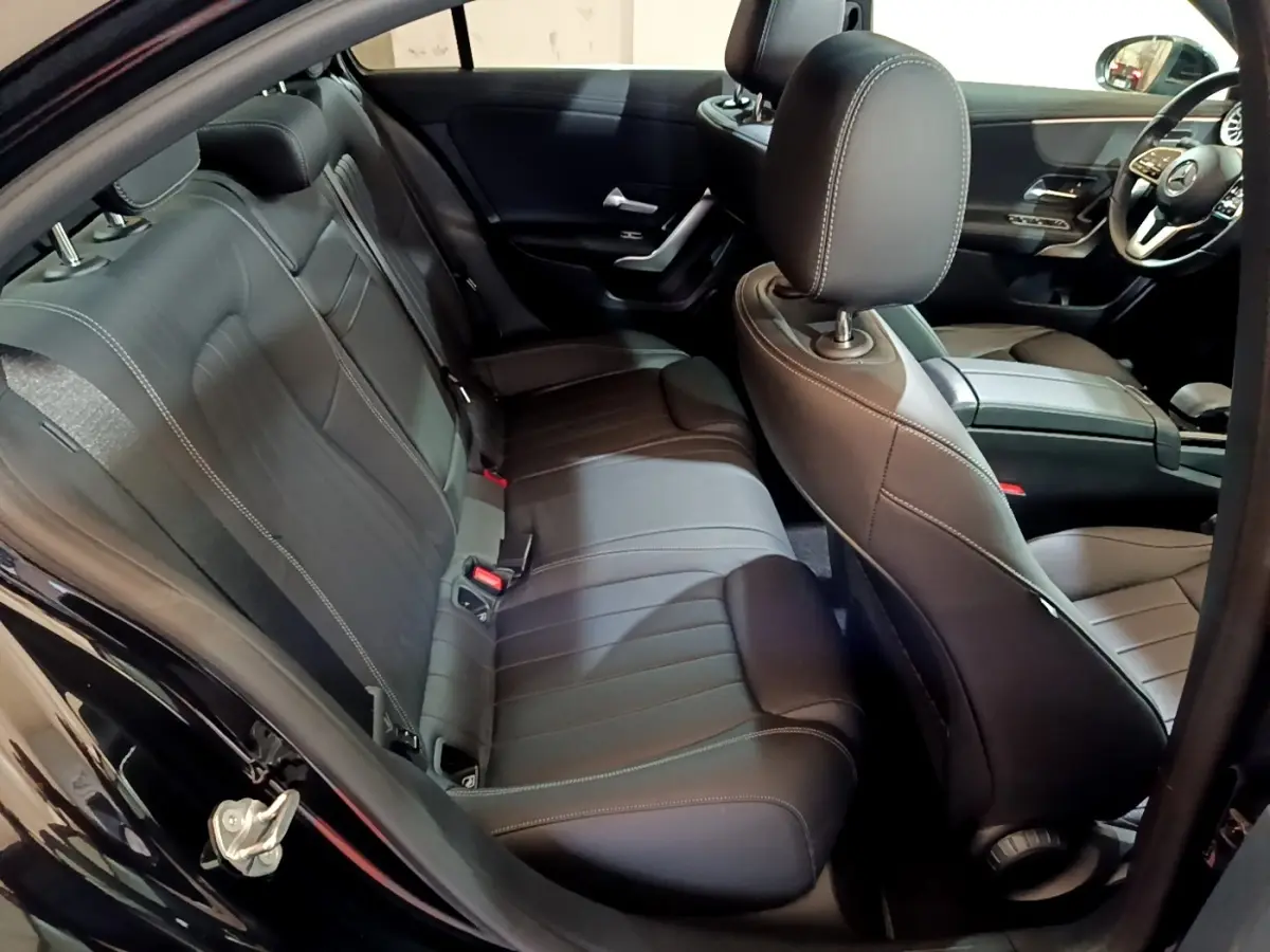 Vue intérieure côté droit de la banquette arrière et sièges avant en cuir noir d'une Mercedes Classe A Berline 2022.