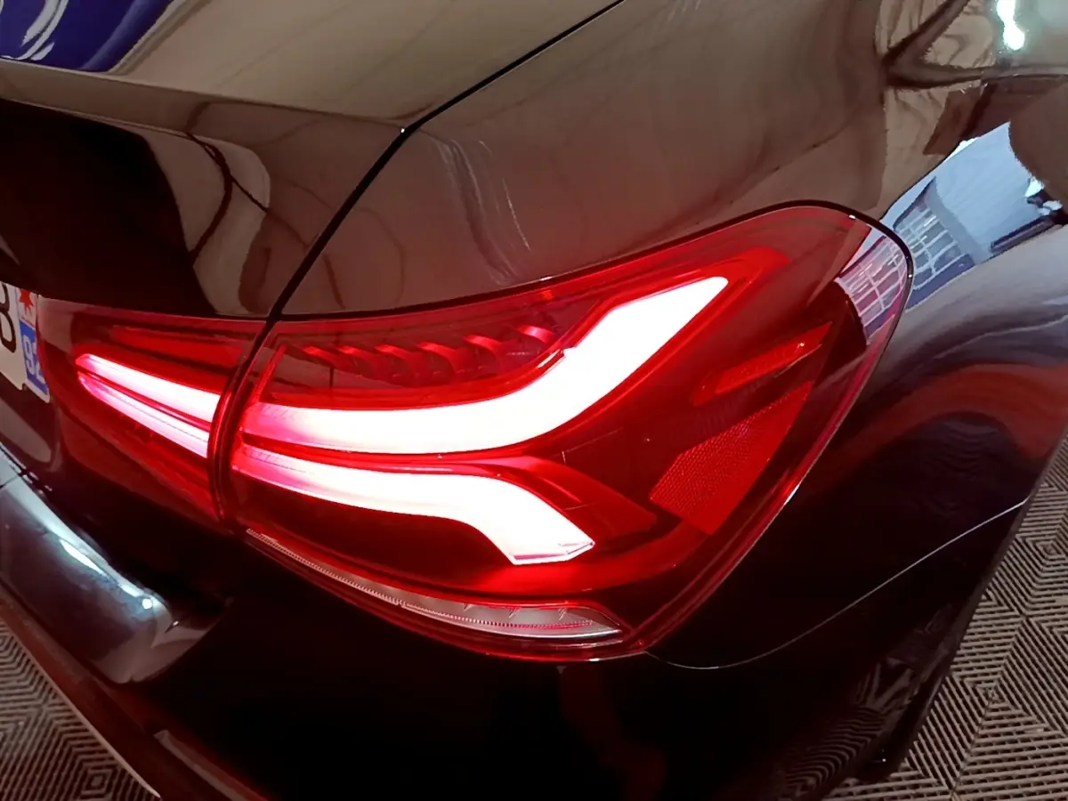 Gros plan sur le feu arrière droit allumé d'une Mercedes Classe A Berline A 200 d Progressive Line noire.