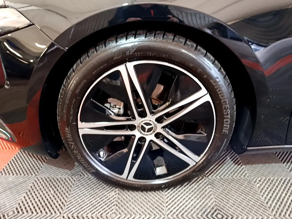 Gros plan sur la roue avant droite noire d’une Mercedes Classe A berline 2022 avec jante alliage bicolore.