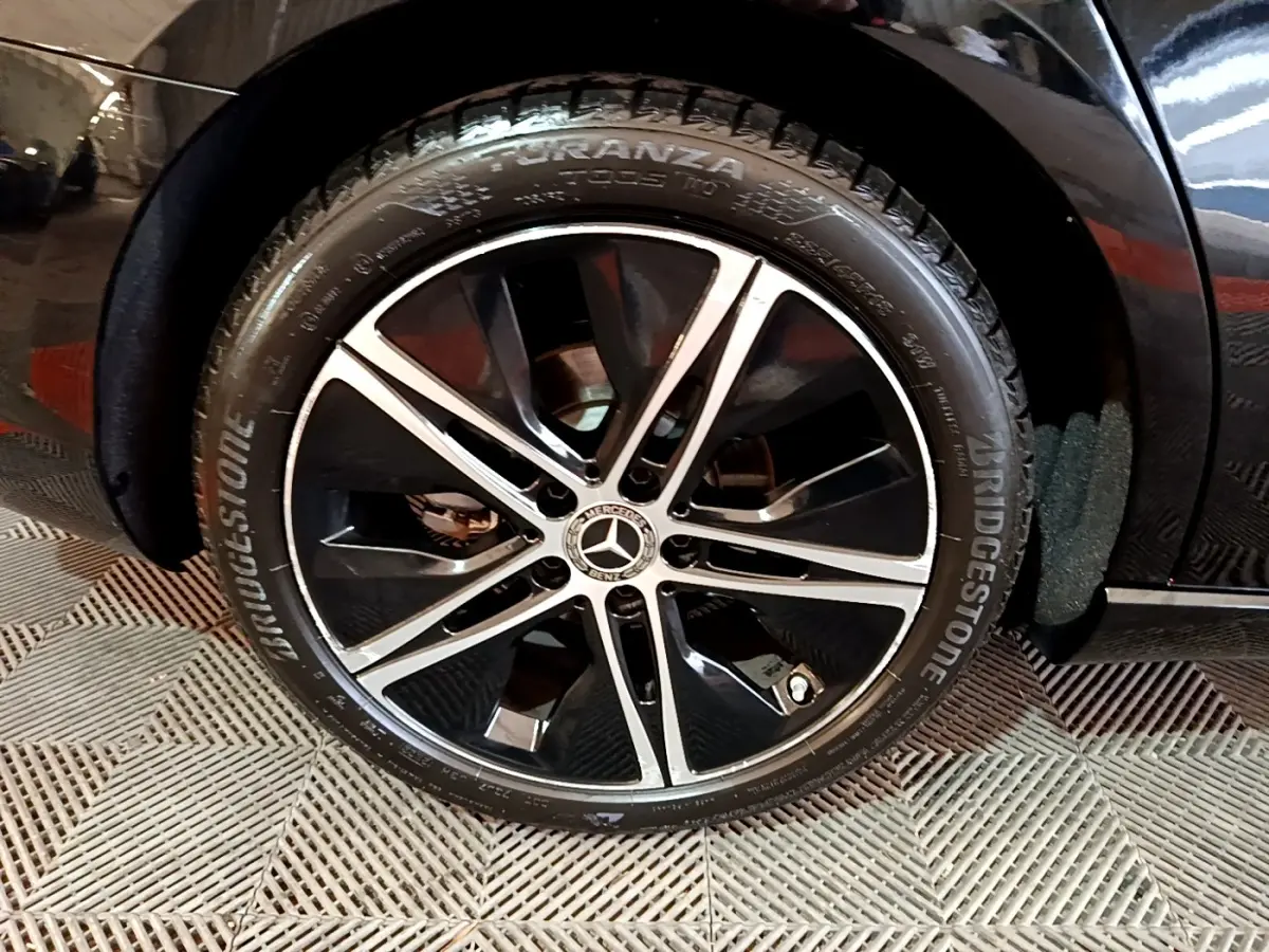 Gros plan sur la roue avant droite noire d’une Mercedes Classe A berline A 200 d avec jante alliage bicolore.