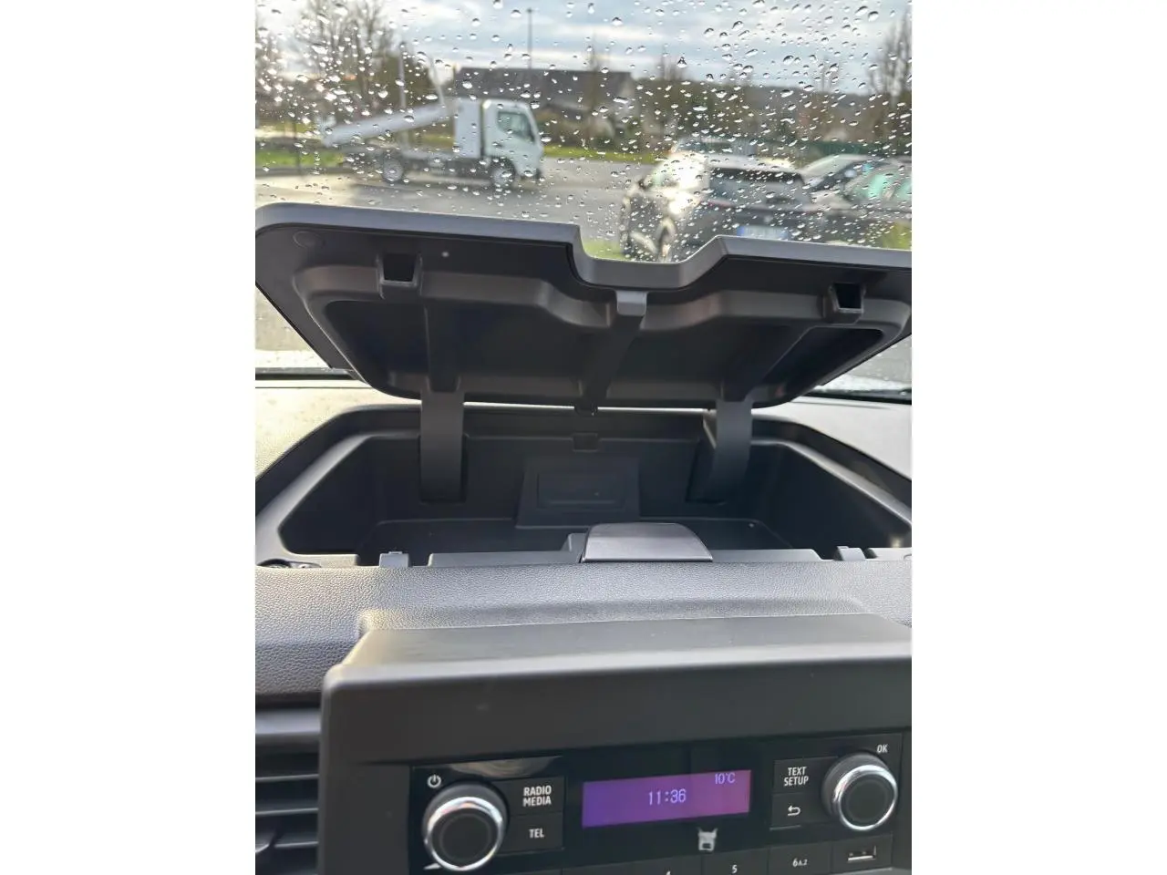 Vue intérieure du Renault Trafic Fourgon L2 gris clair, montrant le rangement ouvert au-dessus de la console centrale.