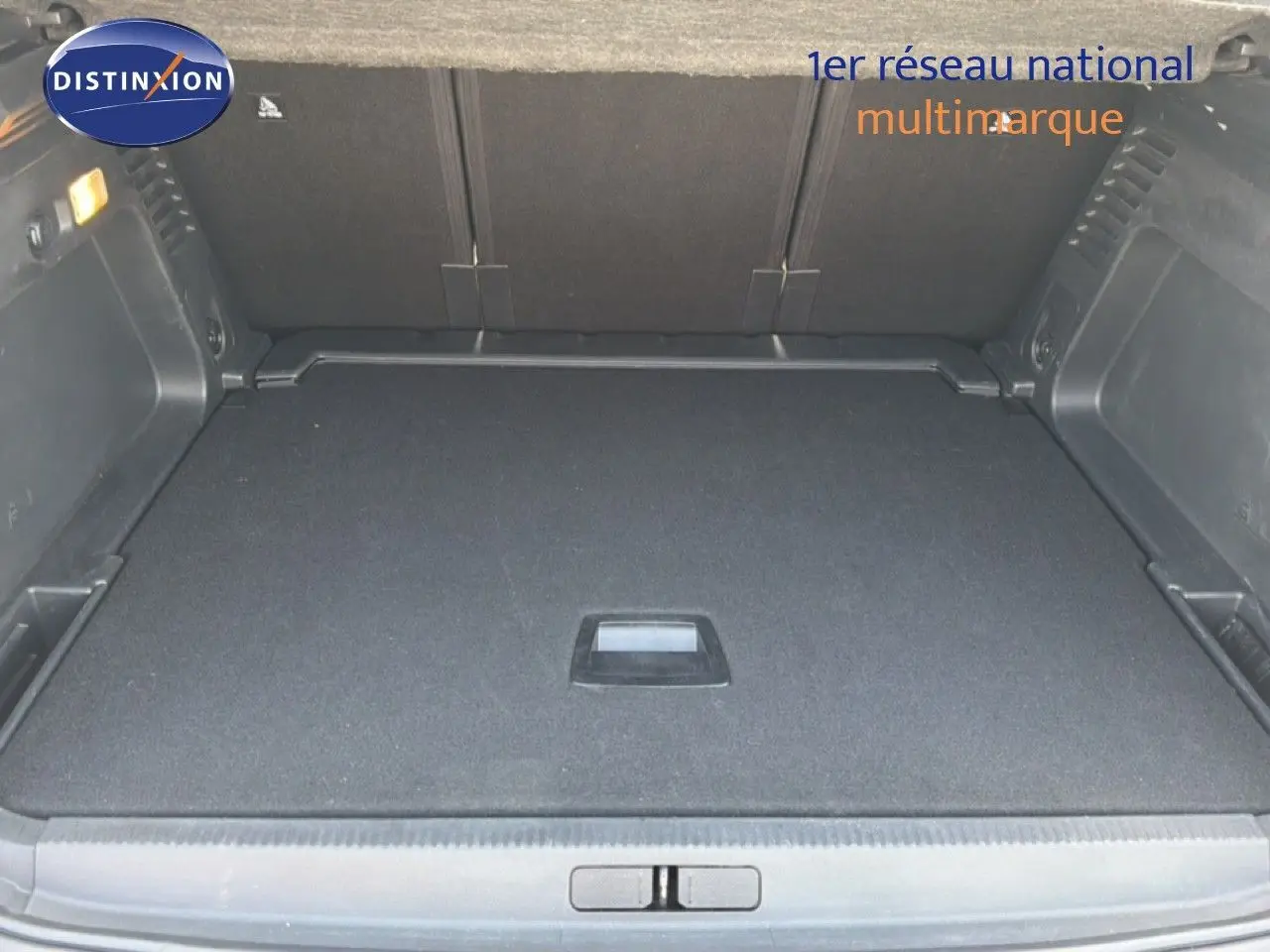 Vue intérieure du coffre spacieux et propre du Citroën C5 Aircross gris acier, avec plancher plat et poignée centrale.