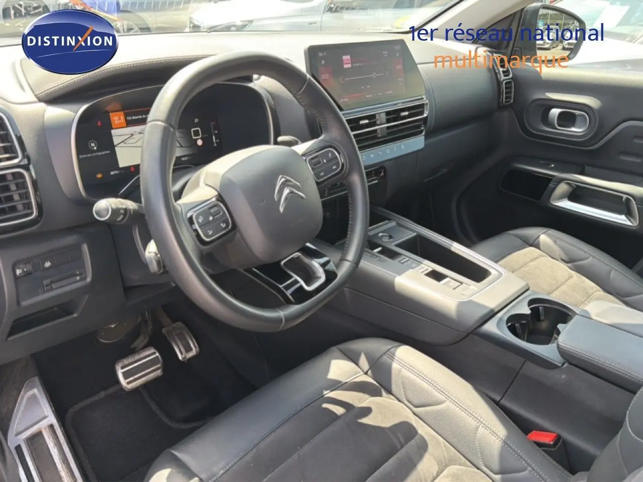 Intérieur du Citroën C5 Aircross 2023 en gris acier, vue côté conducteur montrant volant, tableau de bord et console centrale.