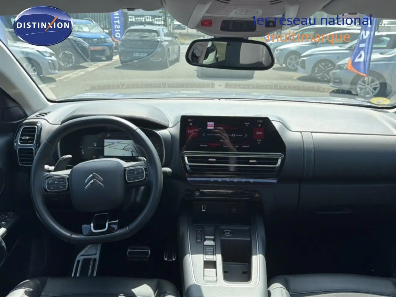 Vue intérieure avant du Citroën C5 Aircross 2023 gris acier, tableau de bord moderne avec écran tactile et volant multifonction.