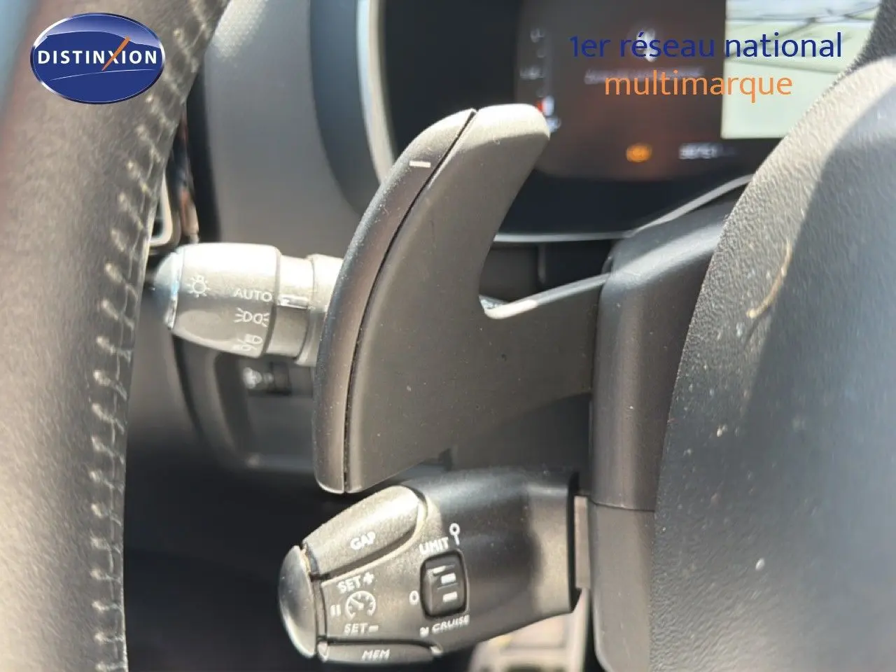 Gros plan sur la commande de régulateur de vitesse à gauche du volant du Citroën C5 Aircross 2023 gris acier.