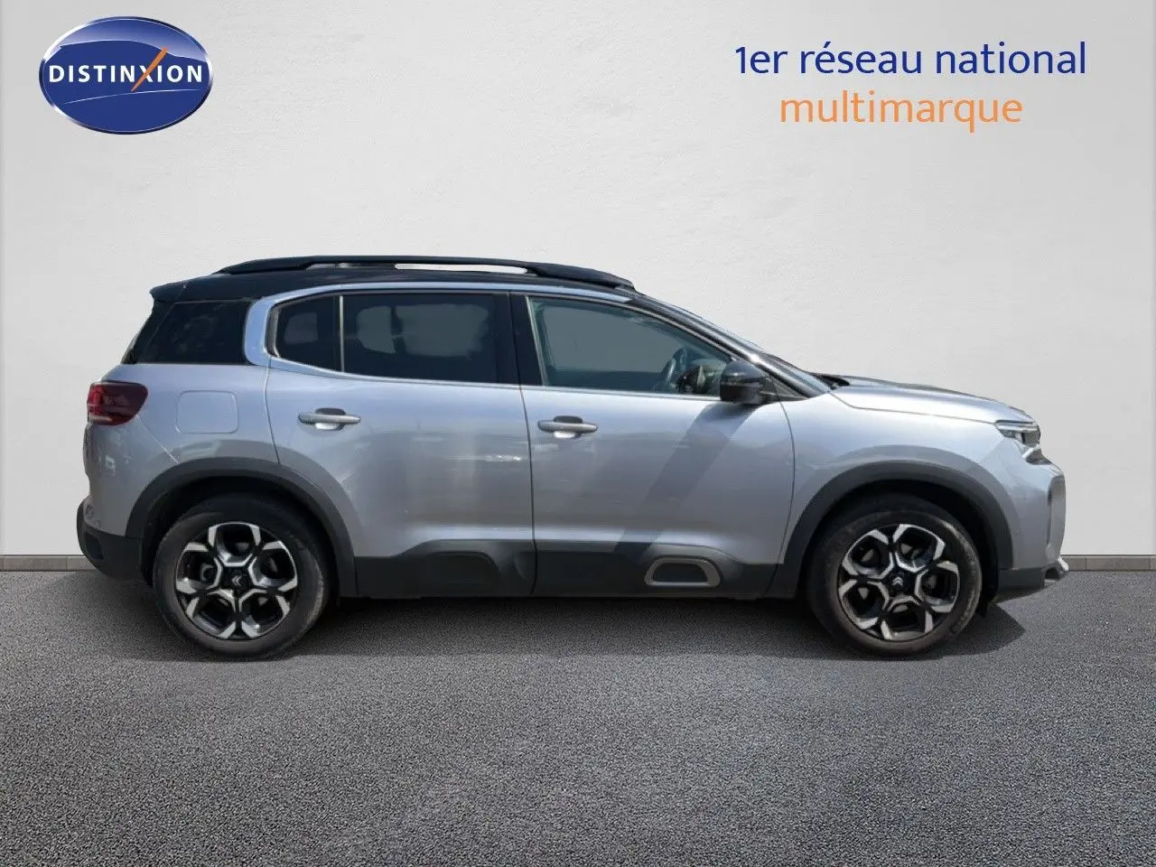 Profil droit d'un Citroën C5 Aircross gris acier 2023 avec toit noir et jantes alliage bicolores.