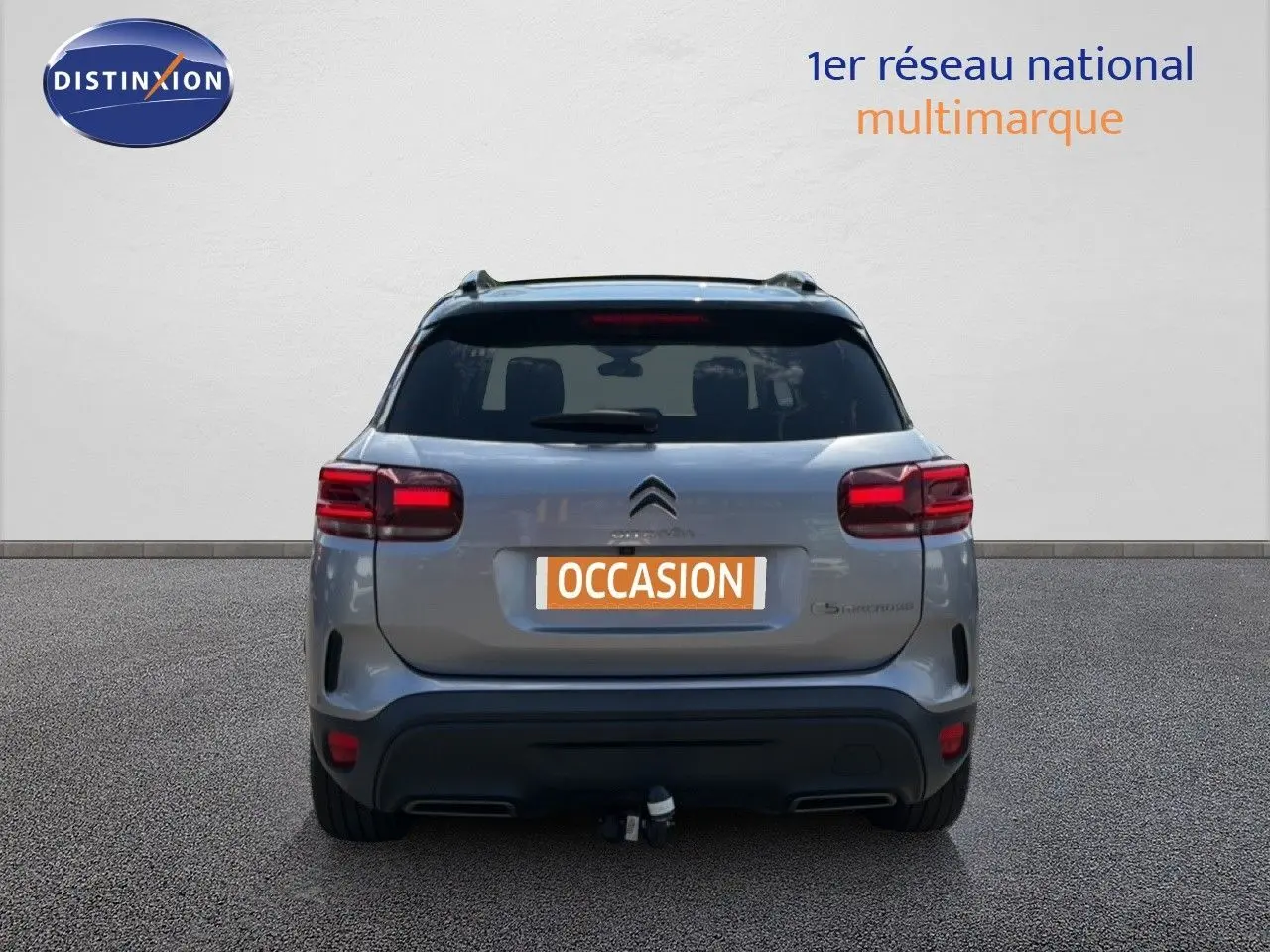 Vue arrière d'un Citroën C5 Aircross gris acier 2023 avec hayon fermé et attelage visible.