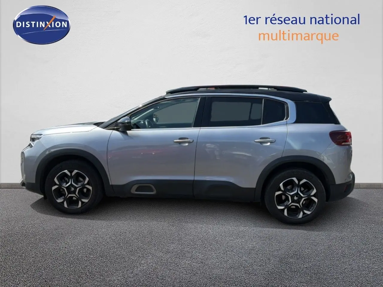 Profil côté gauche d'un Citroën C5 Aircross gris acier 2023 avec toit noir et jantes bi-ton 18 pouces.