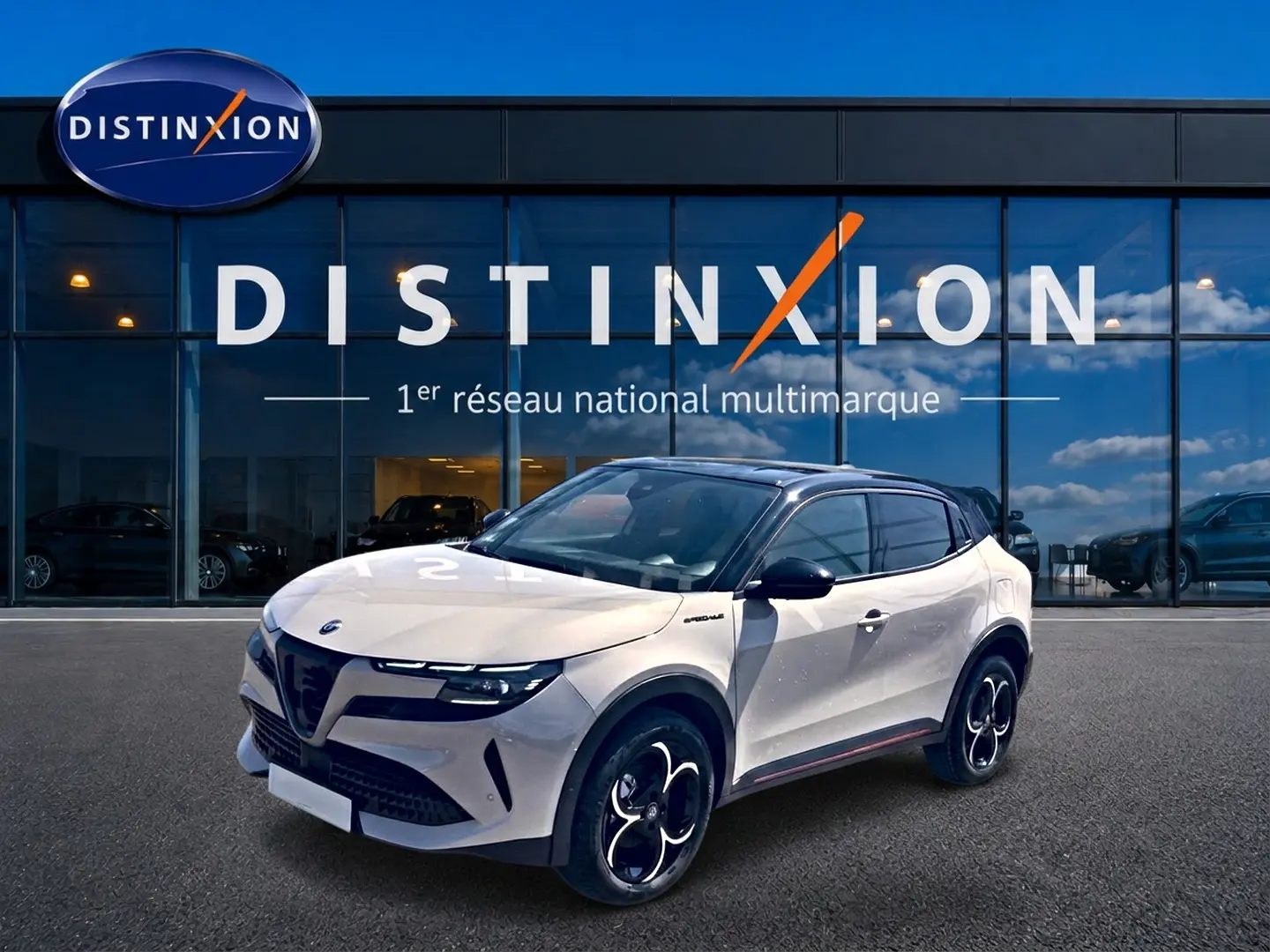 Vue 3/4 avant droite d'une Alfa Romeo Junior 1.2 hybride ivoire et noir, avec jantes alliage et toit noir brillant.