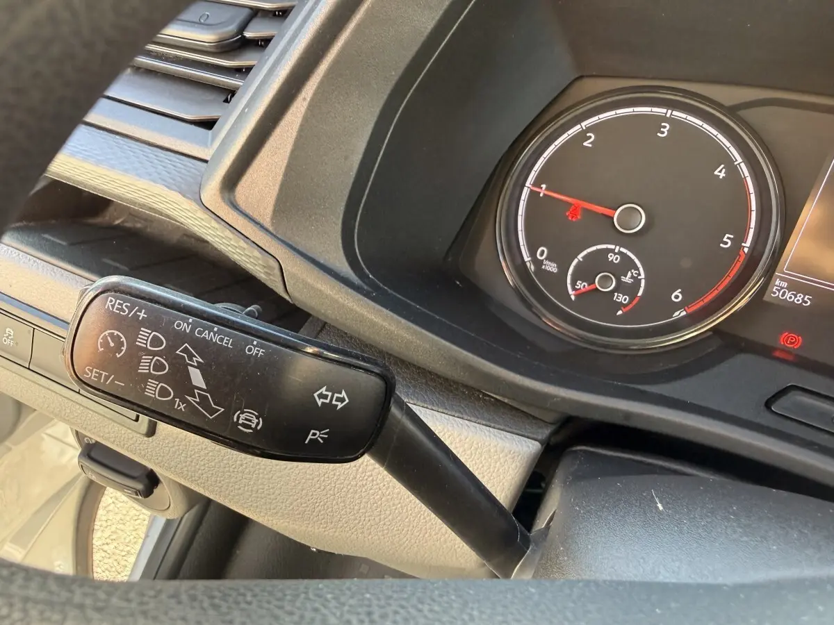 Gros plan sur le levier de commande du régulateur de vitesse et le compte-tours du tableau de bord du Volkswagen Transporter gris clair.