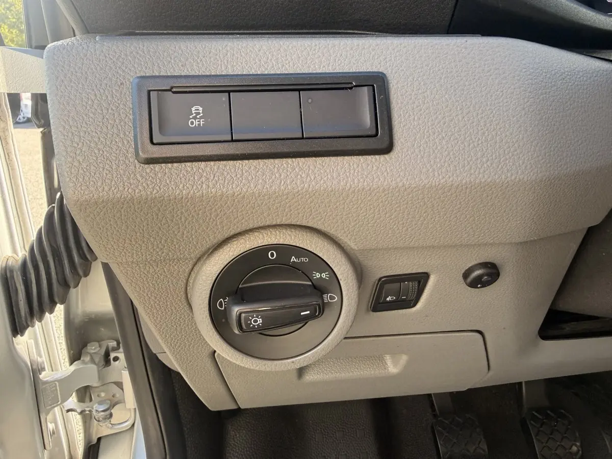 Gros plan sur le panneau de commande des phares gris clair du Volkswagen Transporter 2.0 TDi 110 L2H1 Business 2022.