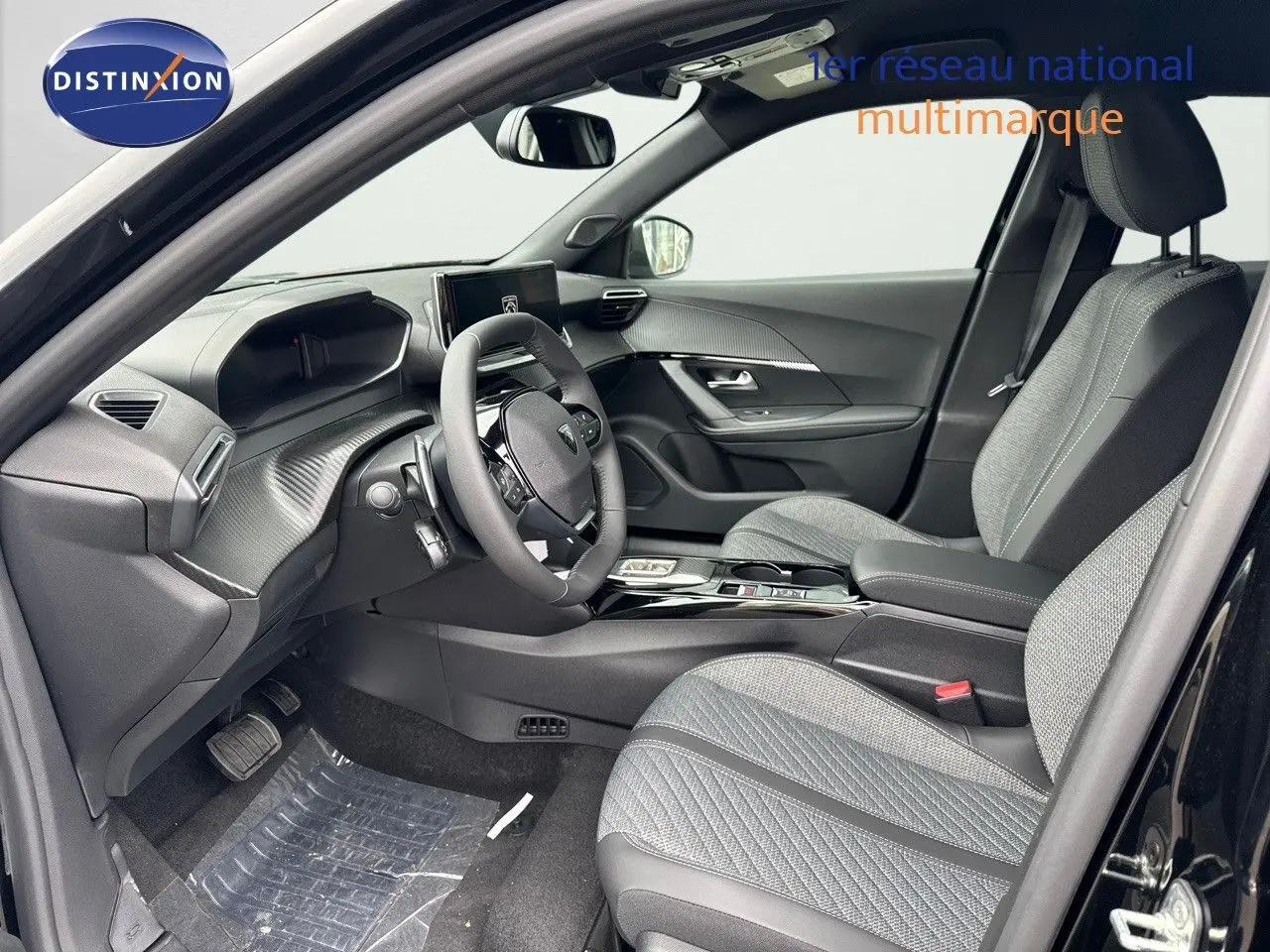 Intérieur avant droit du Peugeot 2008 noir métal 2025, sièges tissu gris et tableau de bord moderne avec écran central.