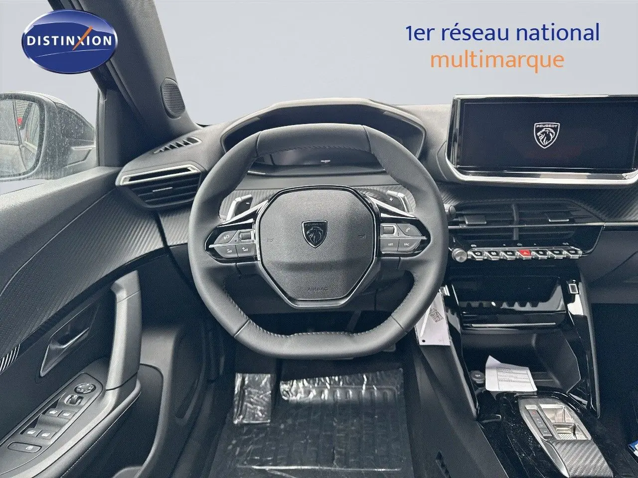 Intérieur noir du Peugeot 2008 Hybrid 136ch, vue frontale sur le volant et la console centrale moderne.