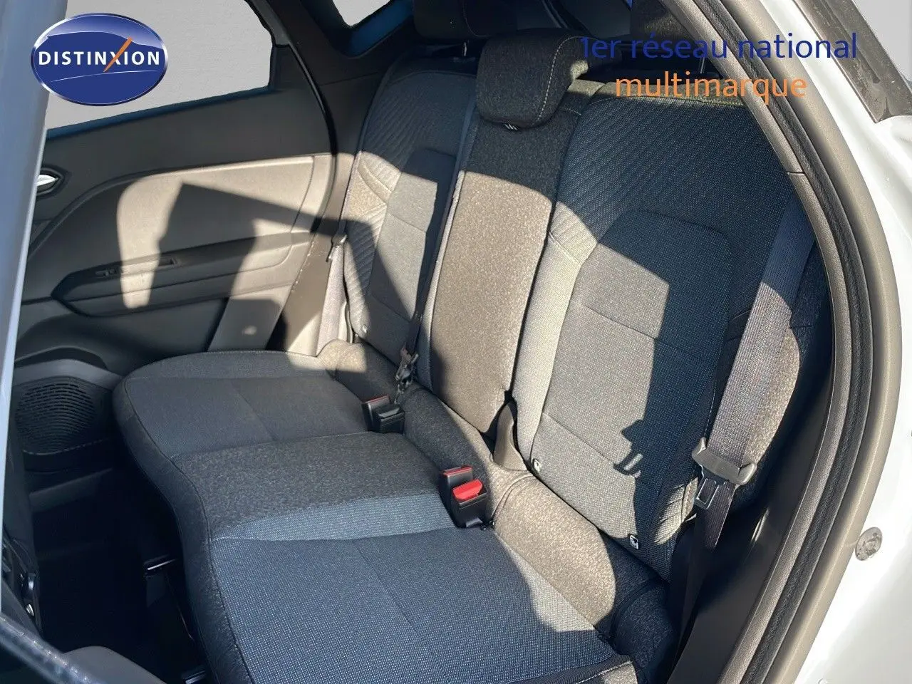 Vue intérieure sur les sièges arrière en tissu gris du Renault Captur E-Tech hybride 2025 avec porte ouverte côté droit.