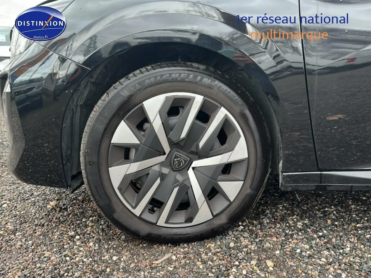 Vue latérale côté gauche d'une Peugeot 208 noire 2025, mettant en valeur la roue avant et la carrosserie brillante.