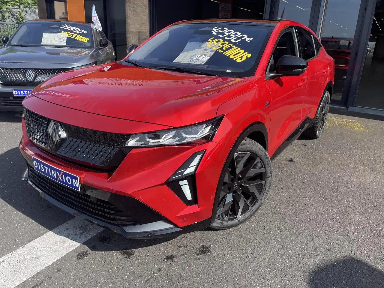 Vue 3/4 avant droite d’une Renault Rafale rouge flamme avec toit noir et jantes noires diamantées.
