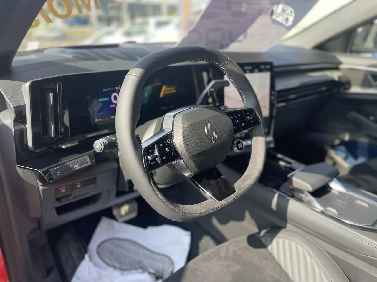 Intérieur Renault Rafale 2025 vu côté conducteur, volant Alcantara, planche de bord noire et écran tactile vertical.