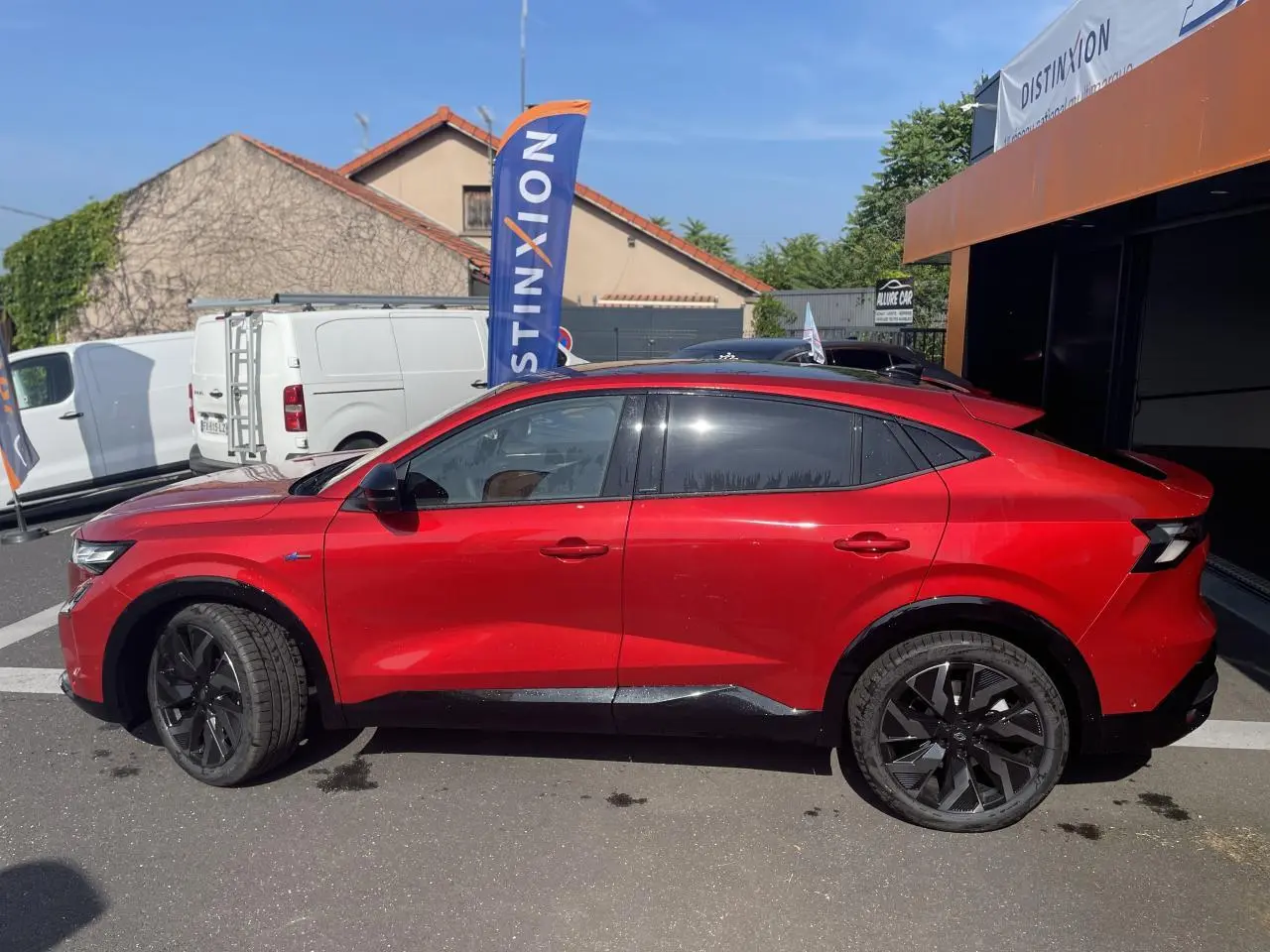 Profil droit de la Renault Rafale rouge avec toit noir, jantes noires et lignes dynamiques visibles en extérieur.