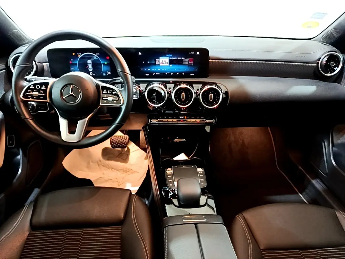 Vue intérieure avant de la Mercedes CLA 200 d Business Line 2021, tableau de bord noir avec écran tactile panoramique.