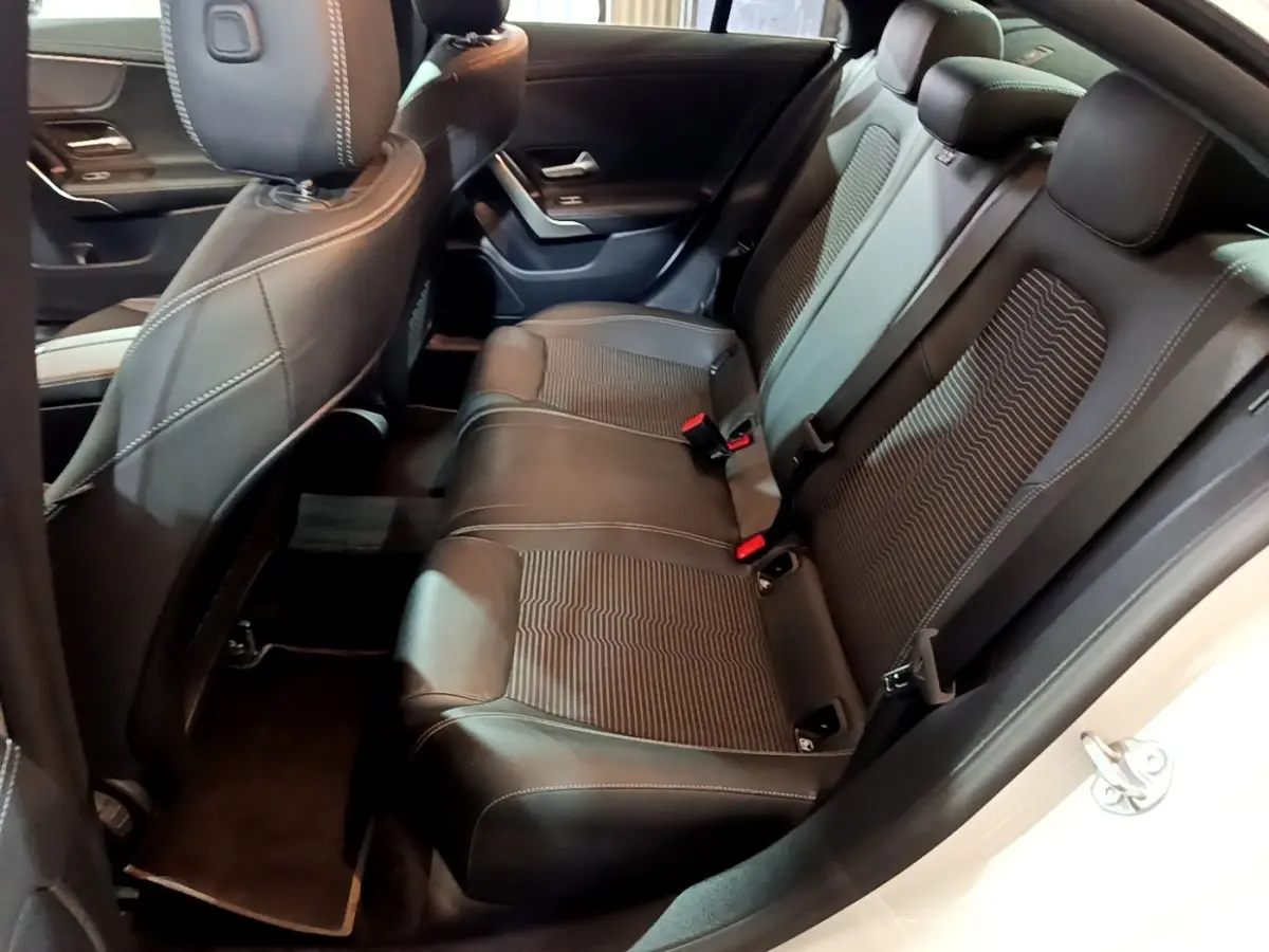 Vue intérieure côté droit des sièges arrière noirs en cuir et tissu d'une Mercedes CLA 200 d Business Line blanche.
