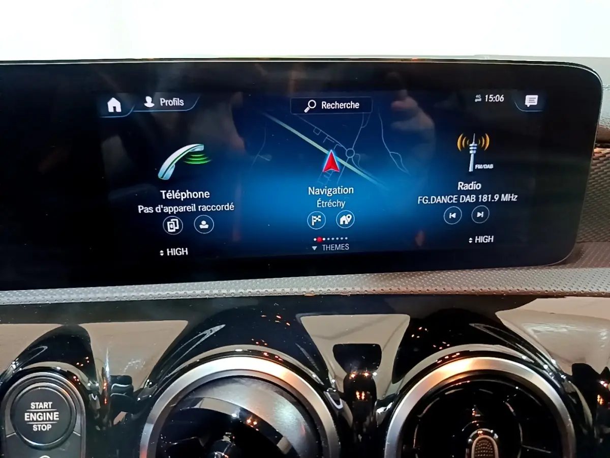 Vue rapprochée de l’écran tactile central et des aérateurs ronds noirs du tableau de bord de la Mercedes CLA 200 d Business Line blanche.