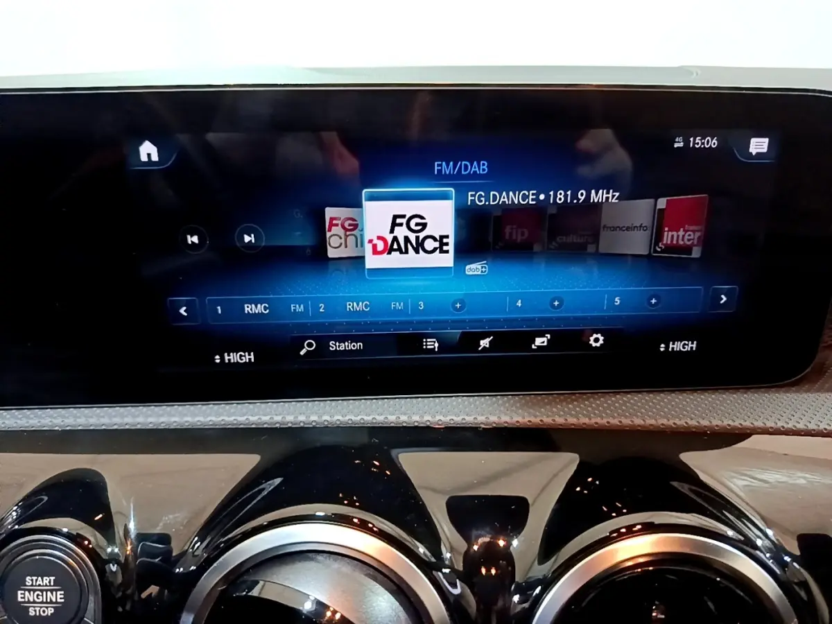 Vue rapprochée de l’écran tactile multimédia et des aérateurs ronds noirs du tableau de bord d’une Mercedes CLA 200 d blanche.