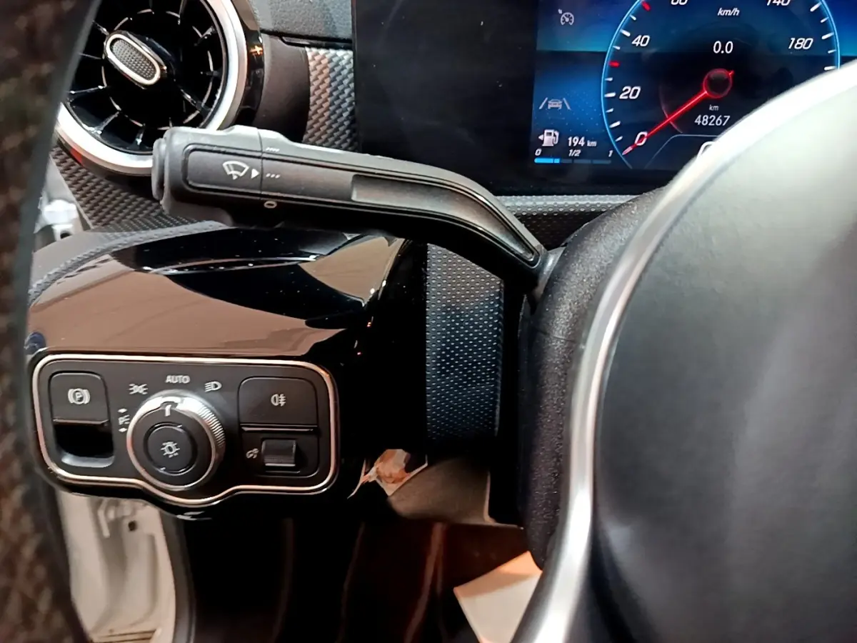 Détail du tableau de bord noir et volant partiel de la Mercedes CLA 200 d Business Line, avec commandes et écran digital.