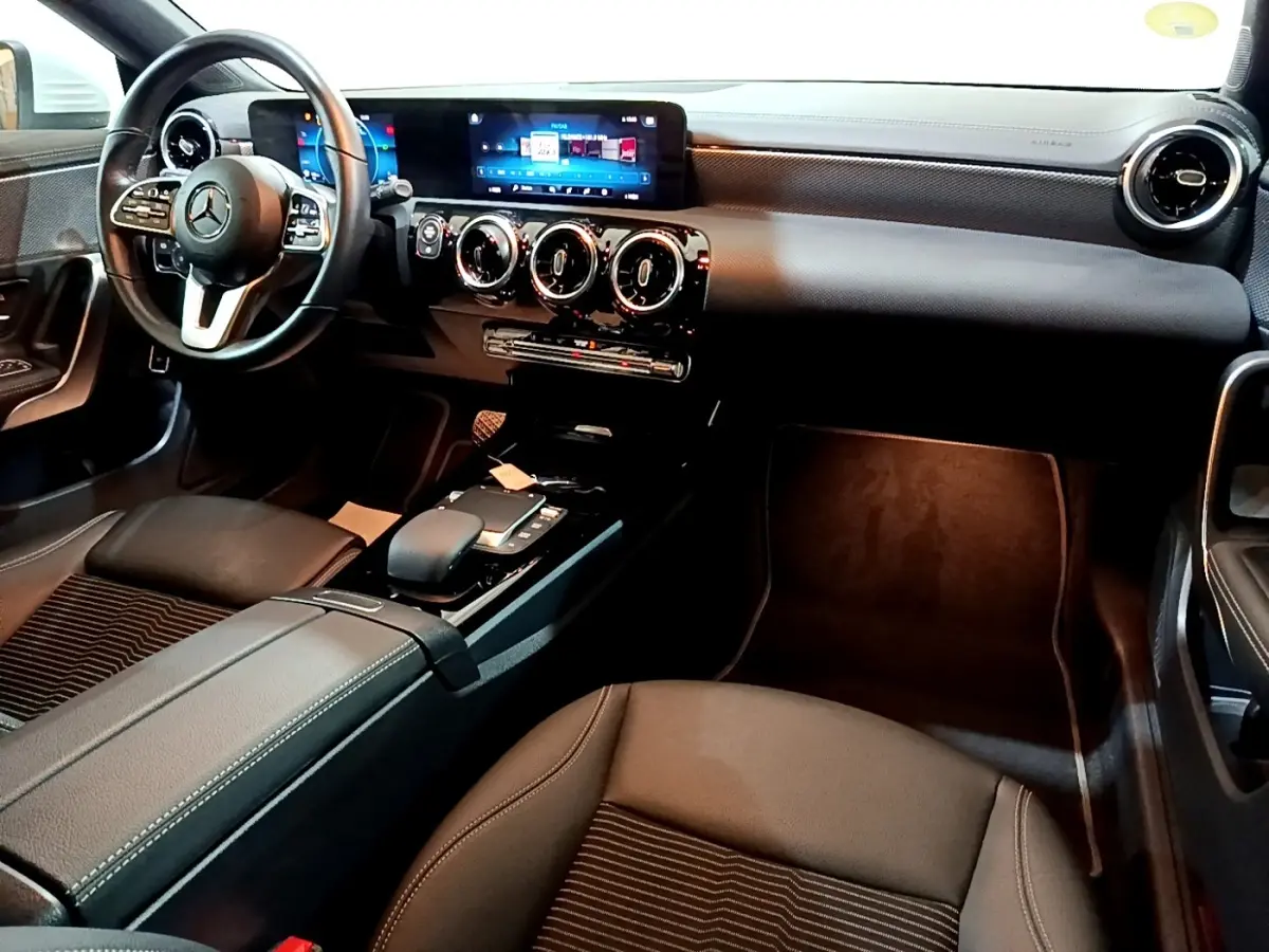 Intérieur noir de la Mercedes CLA 200 d Business Line 2021, vue côté conducteur avec tableau de bord numérique et écran tactile.