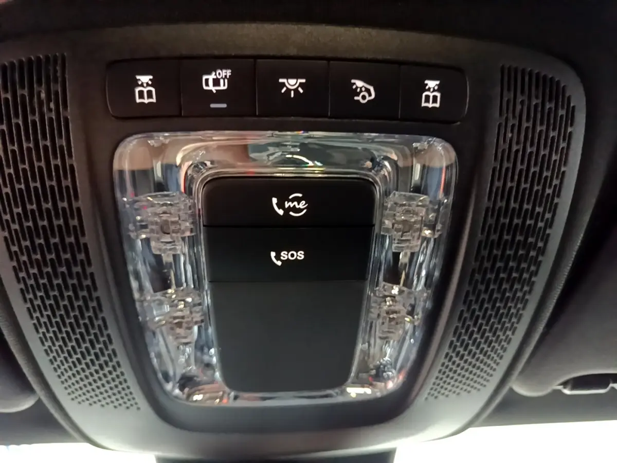 Vue en gros plan du plafonnier noir avec boutons d’appel d’urgence et éclairage intérieur d’une Mercedes CLA 200 d blanche.
