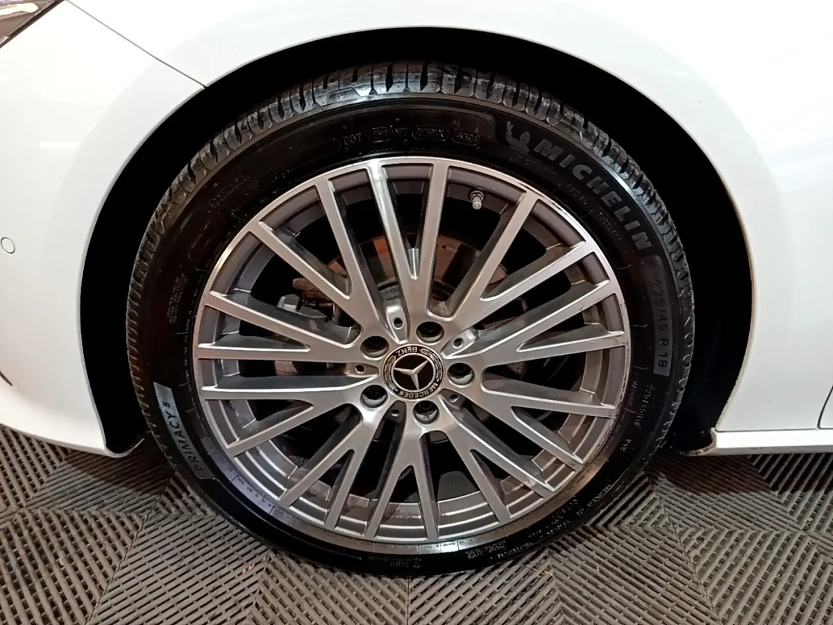 Gros plan sur la roue avant droite d’une Mercedes CLA 200 d Business Line blanche, jante alliage multi-branches.