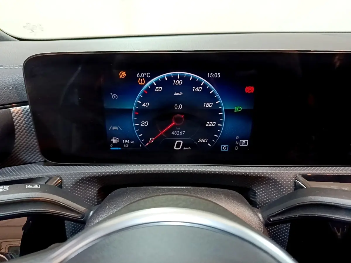 Tableau de bord numérique de Mercedes CLA 200 d Business Line 2021, affichage vitesse et alertes, vue frontale rapprochée.