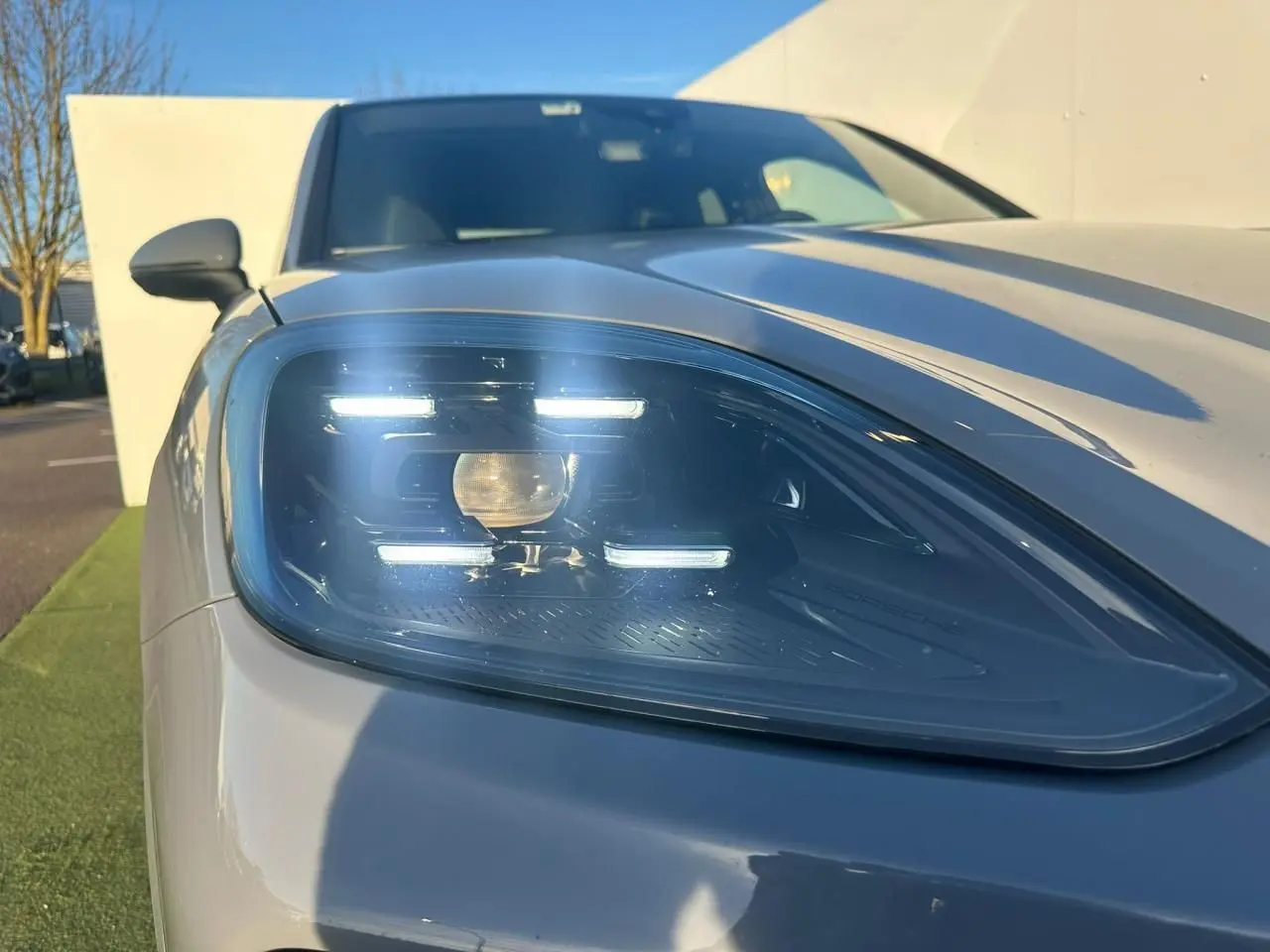 Gros plan sur le phare avant gauche du Porsche Cayenne 2024 gris arctique, mettant en valeur son design LED distinctif.