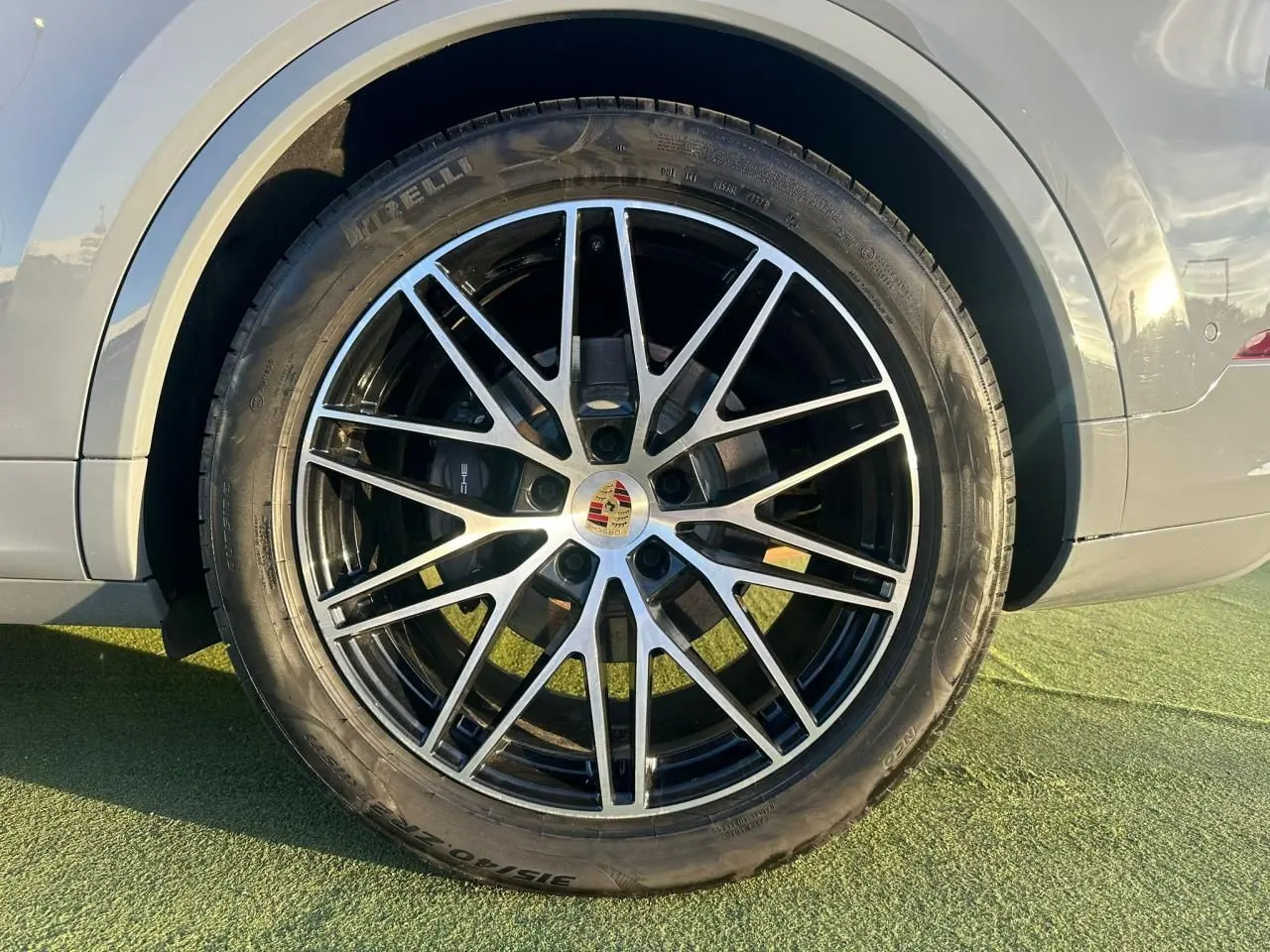 Gros plan sur la roue avant droite du Porsche Cayenne III Coupe 3.0 V6 S e-Hybrid 2024 en gris arctique.