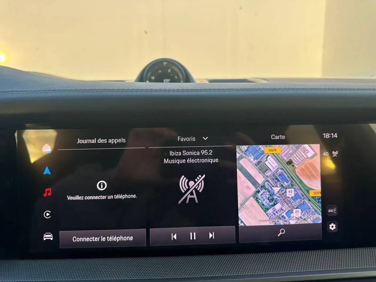 Vue rapprochée de l'écran tactile central du Porsche Cayenne 2024 gris arctique, affichant navigation et musique.