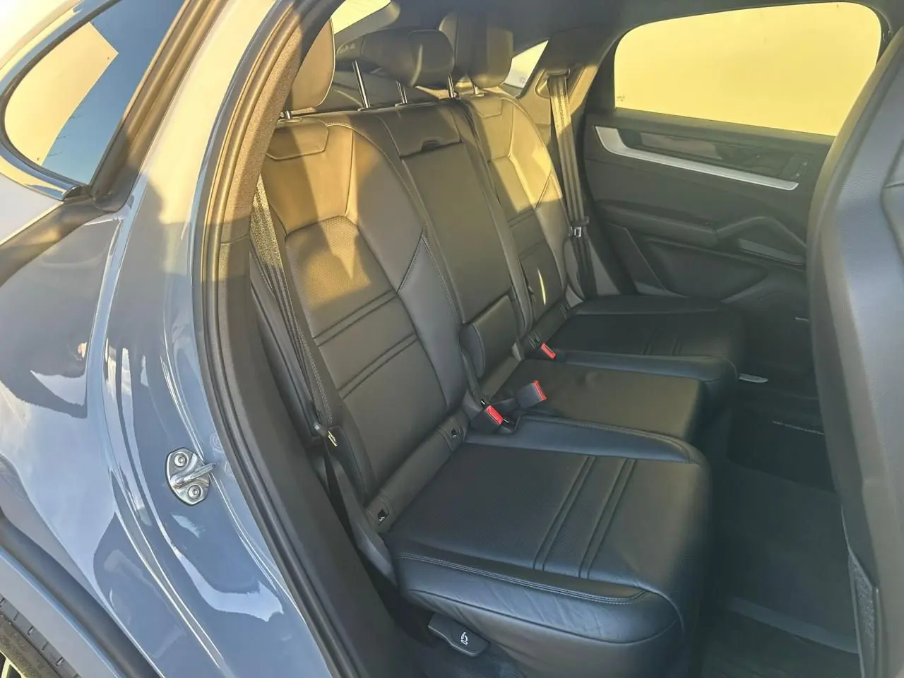 Vue intérieure côté gauche des sièges arrière en cuir noir du Porsche Cayenne III Coupe 2024 gris arctique.