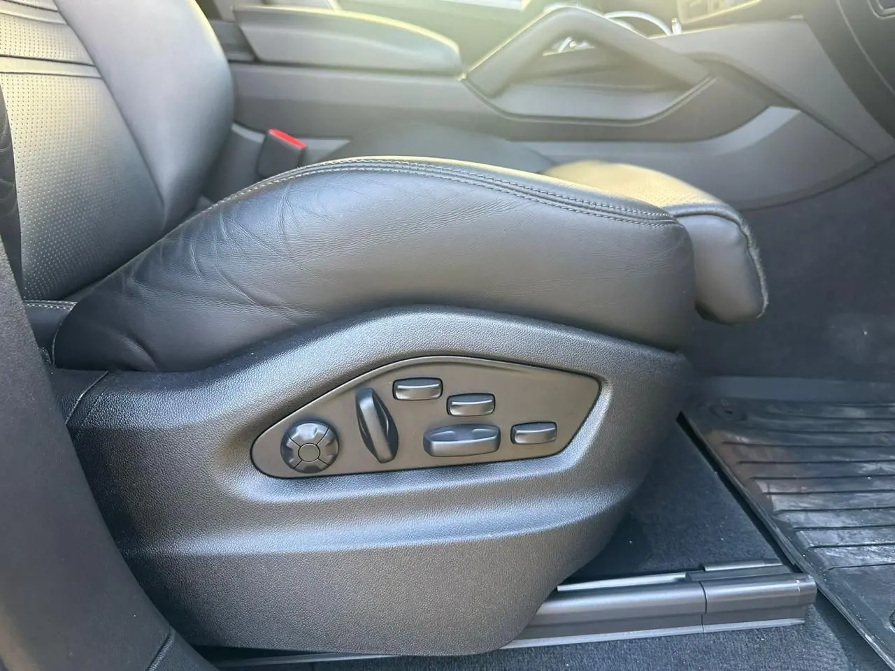Gros plan sur les commandes électriques du siège conducteur en cuir noir d’un Porsche Cayenne 2024.