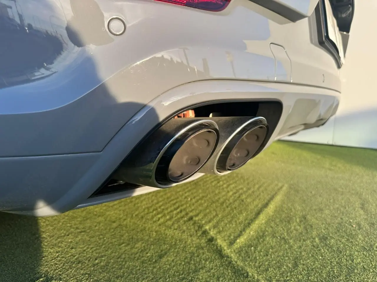 Gros plan sur la double sortie d’échappement arrière droite du Porsche Cayenne Coupé gris arctique 2024.